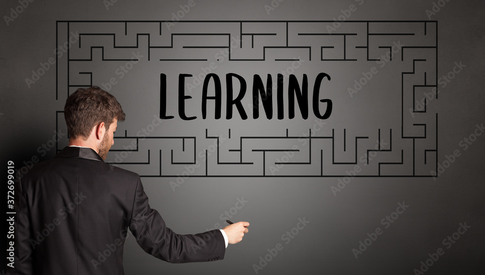 businessman drawing maze with LEARNING inscription, business education concept businessman drawing maze with LEARNING inscription, business education concept