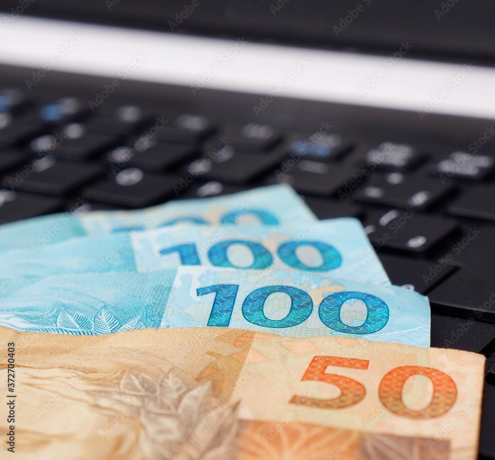 Brazilian money on computer keyboard. Online shopping concept.
Brazilian money on computer keyboard. Online shopping concept.