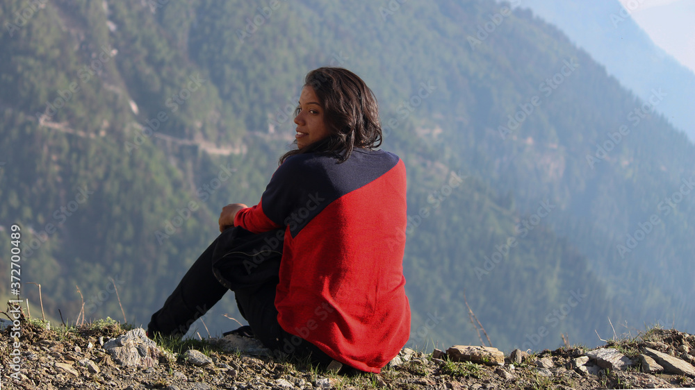 Naklejka premium Young Indian Female Sitting on the edge of the mountain