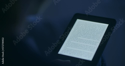 A woman reading an e-book in the evening or by night.