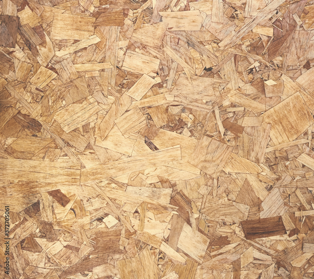pressed wood chips board background. OSB (oriented strand board) is made by combining small pieces of various sizes of wood.