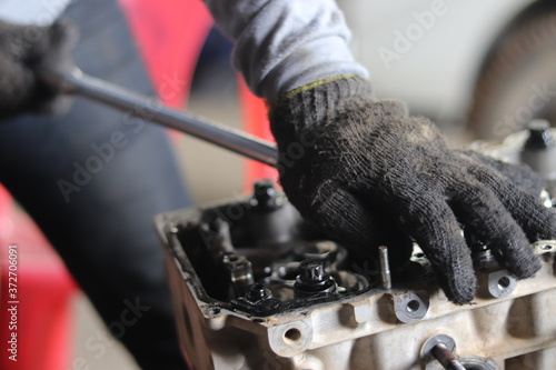 The mechanic is checking the engine.