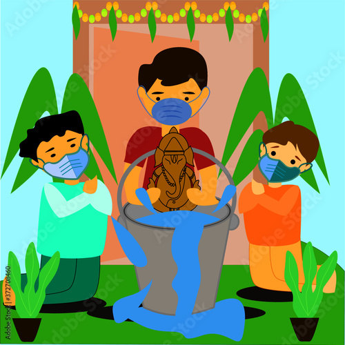  Celebrating Eco-friendly Ganesha festival, Boys doing immersed of Hindu God Ganesha to the bucket at infront of home with wearing surgical mask due to pandemic of coronavirus, covid-19. photo