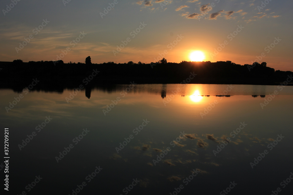 Fototapeta premium Summer landscape with the sun setting over the river. Sunset background