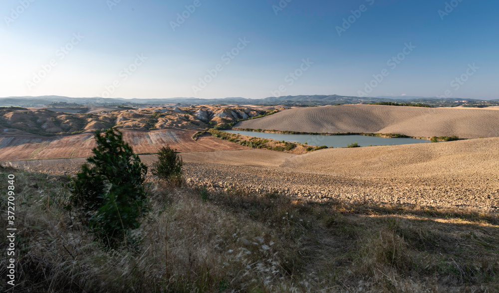 Panoramic view from Crete Senesi, a scenic tuscan zone in the Tuscany countryside with beautiful and characteristic hills 