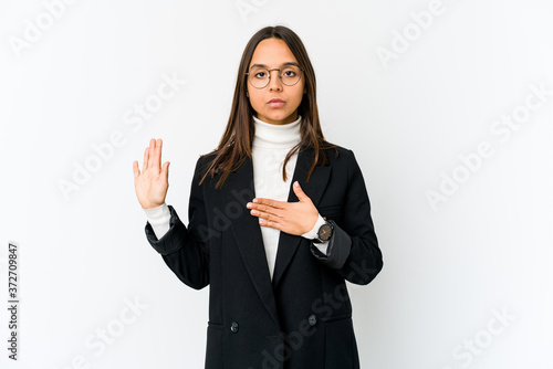 Konstfotografi Young mixed race business woman isolated on white background taking an oath, putting hand on chest