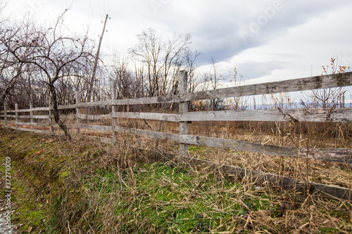 Wooden fence at farmland, autumn season, rural landscape