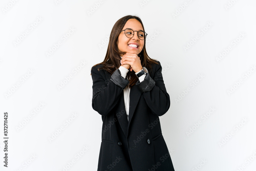 Young mixed race business woman isolated on white background keeps hands under chin, is looking happily aside. Young mixed race business woman isolated on white background keeps hands under chin, is looking happily aside.