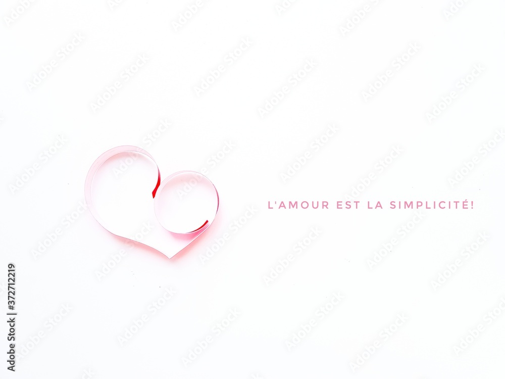The heart is made of red paper on a white background. Text Love is simplicity in English . Valentine's Day.