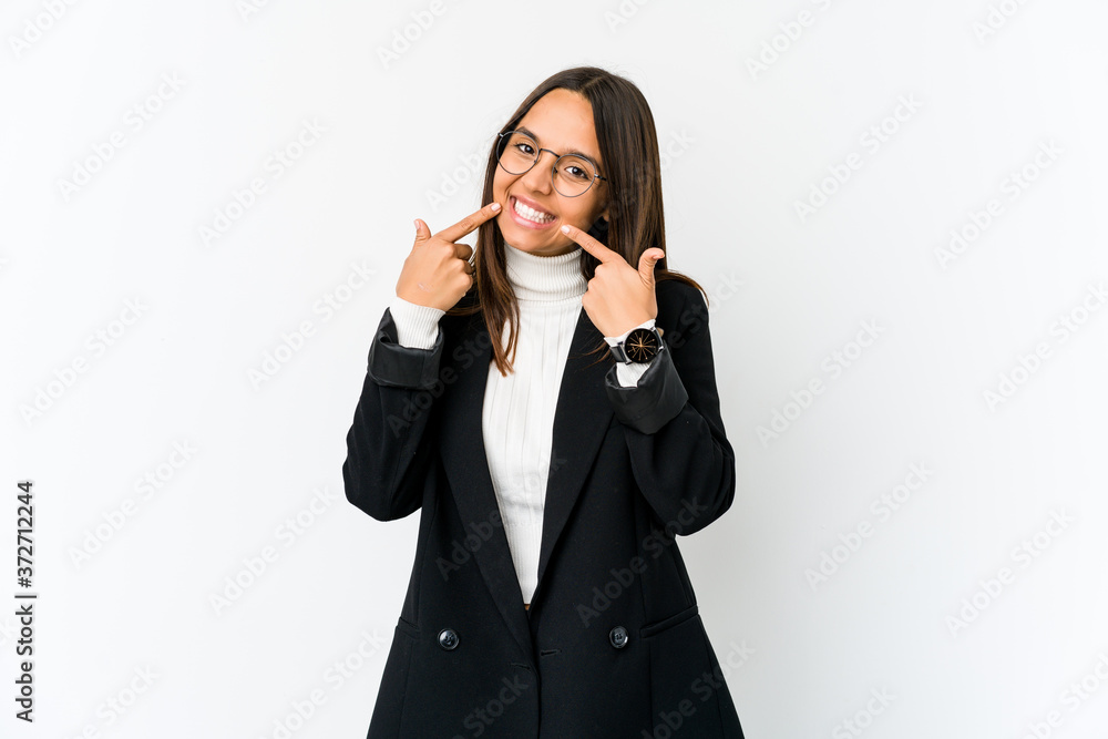 Young mixed race business woman isolated on white background smiles, pointing fingers at mouth. Young mixed race business woman isolated on white background smiles, pointing fingers at mouth.