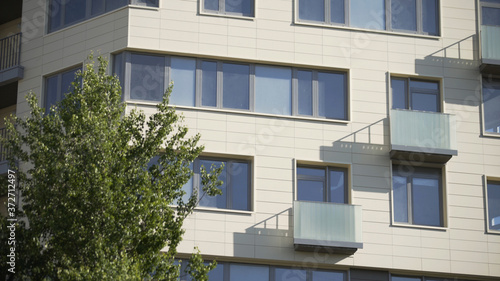 New prefab house. Apartments in panel houses. The facade of a residential modern building with balconies and windows, close-up. Many new floors