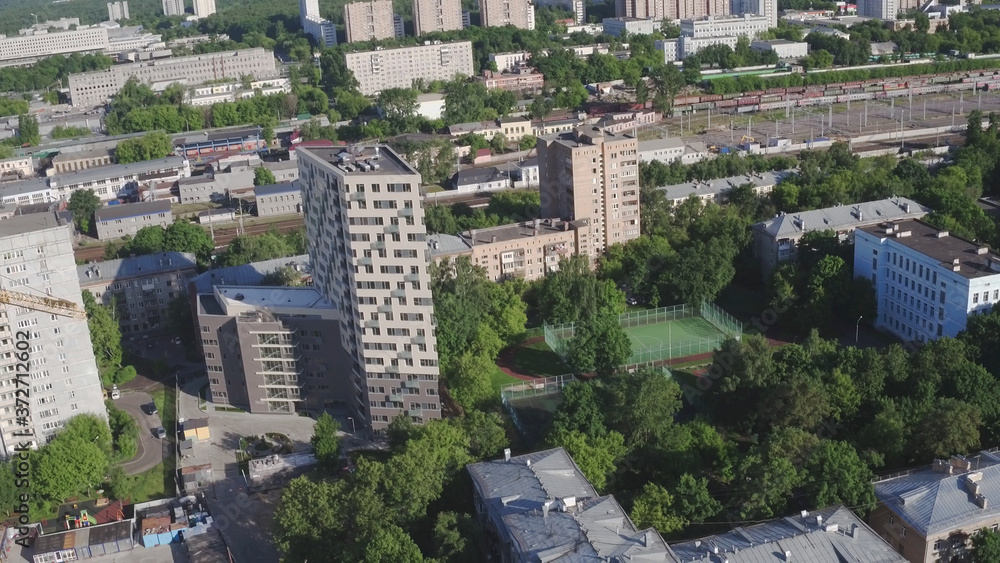 Drone footage of modern large apartment building. Development infrastructure city for big population, modern skyscrapers and tall edifices of megapolis, urban transportation system.