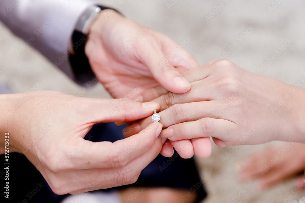 Closeup hands of groom and bride in wearing wedding ring ceremony. Diamond ring for engagement
