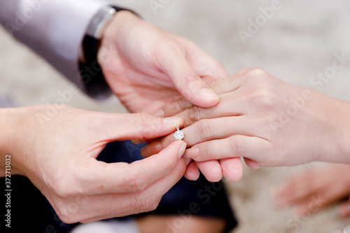Closeup hands of groom and bride in wearing wedding ring ceremony. Diamond ring for engagement