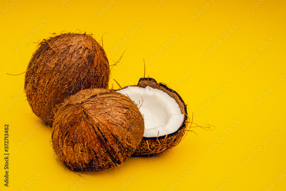 Parts of coconut on a colored background. Close up. Fresh ripe coconut broken into pieces. Parts of coconut on a colored background. Close up. Fresh ripe coconut broken into pieces.