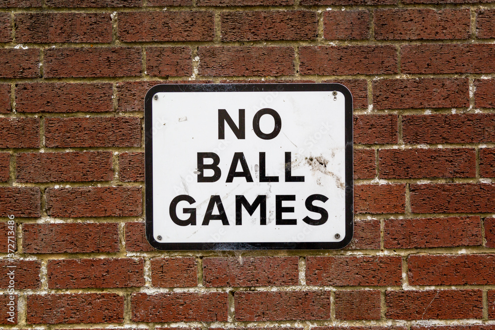 A No ball games sign on a brick wall on the side of a property A No ball games sign on a brick wall on the side of a property