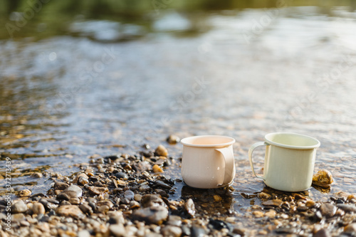 two metal cups with tea at river side © anut21ng Stock