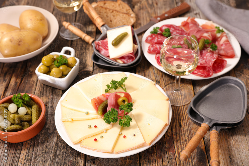 raclette cheese, salami and prosciutto ham with wine and potato raclette cheese, salami and prosciutto ham with wine and potato