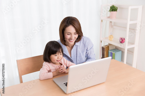 ノートパソコンを見る親子
