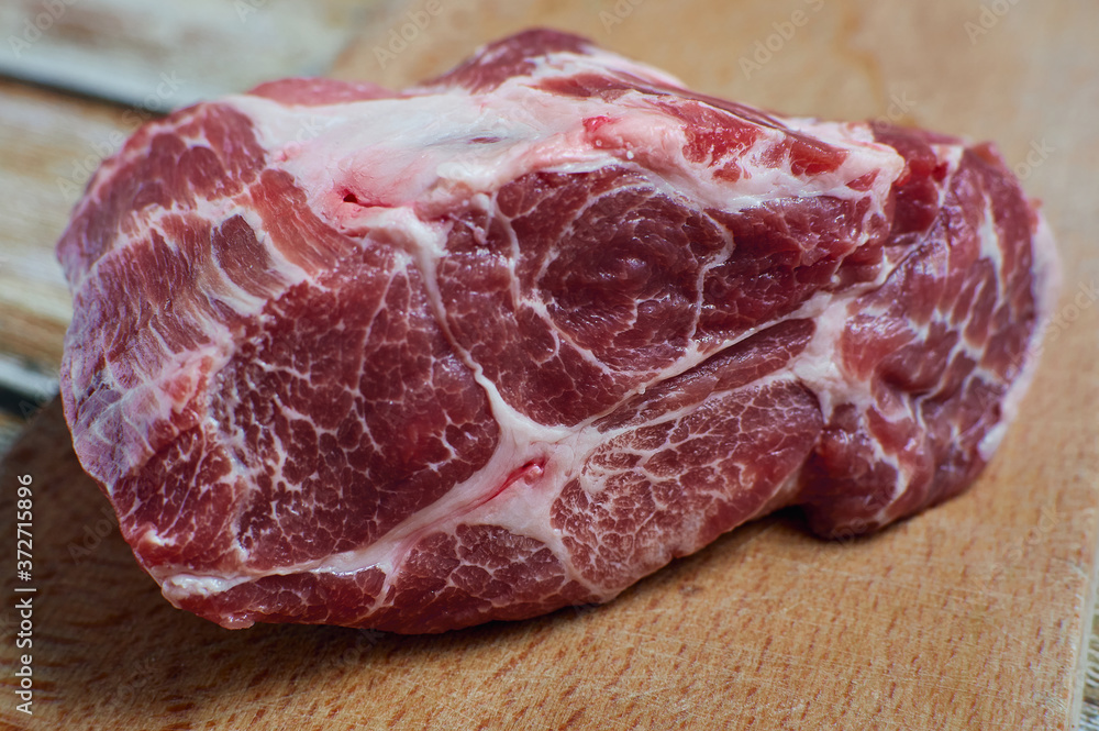 A piece of fresh meat. Raw marbled pork in a cut on a wooden cutting board. A piece of juicy meat for a delicious dish, the concept of correct nutrition. A piece of fresh meat. Raw marbled pork in a cut on a wooden cutting board. A piece of juicy meat for a delicious dish, the concept of correct nutrition.