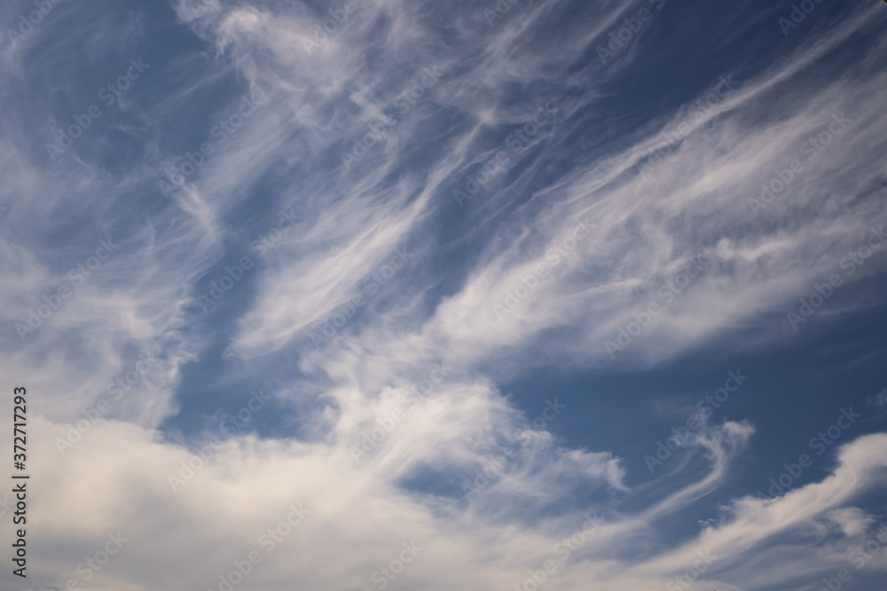 Blue sky background with big white tiny stratus cirrus striped clouds