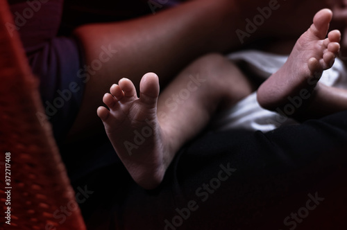 In selective focus of  Newborn baby foot,blurry light around © Watcharin