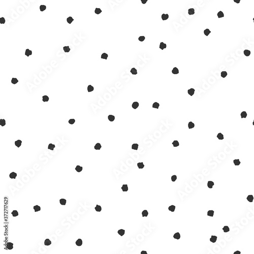 Seamless abstract pattern of little black shabby dots or spots on white.