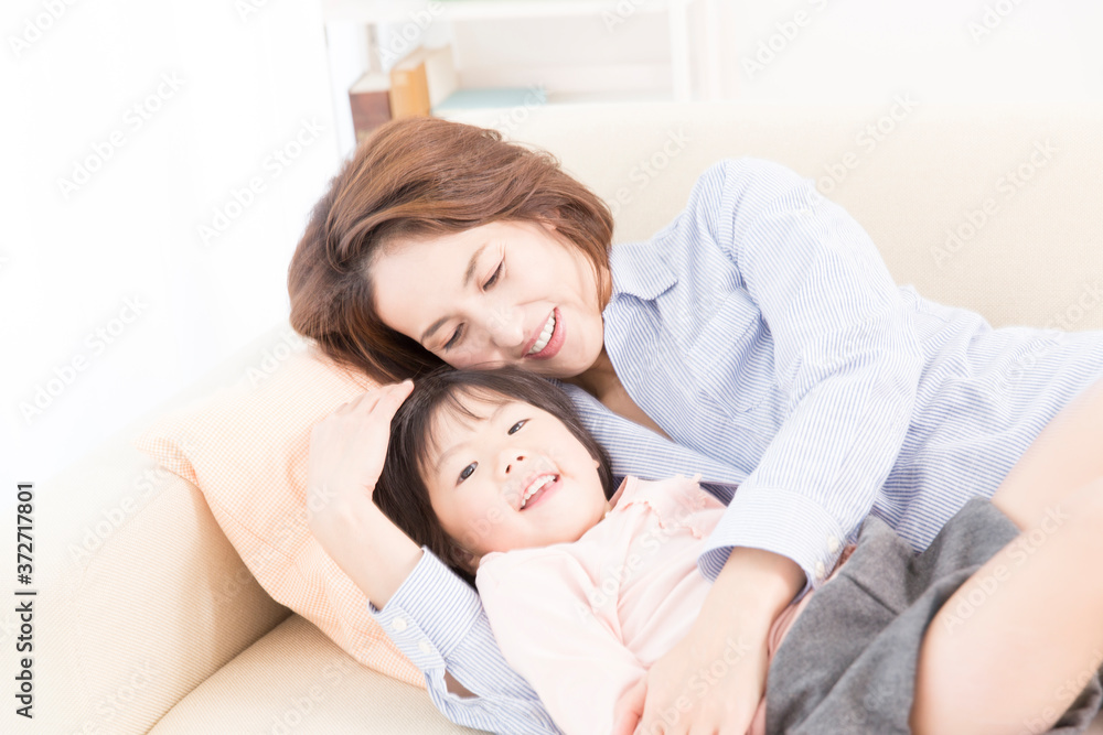 ソファで横になる母と娘 ソファで横になる母と娘