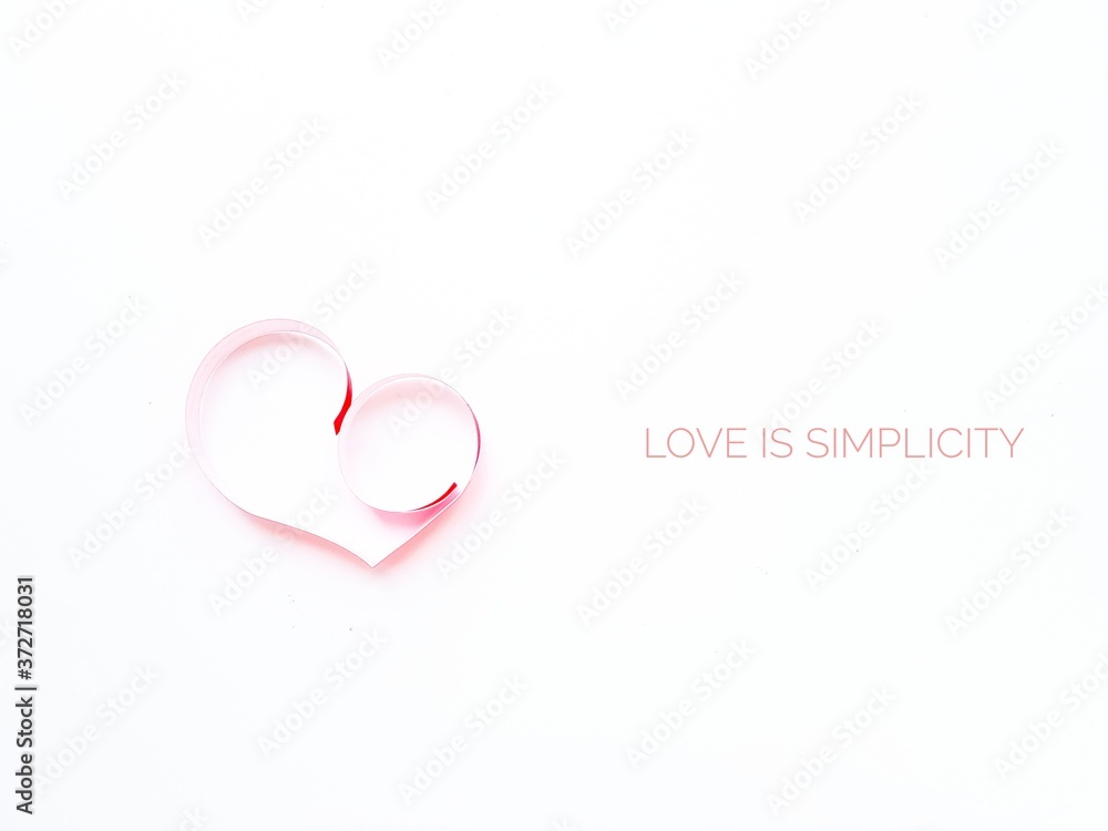 The heart is made of red paper on a white background. Text Love is simplicity in English. Valentine's Day.