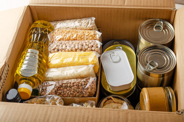 Set of uncooked foods in carton box prepared for disaster emergency conditions or giving away closeup view