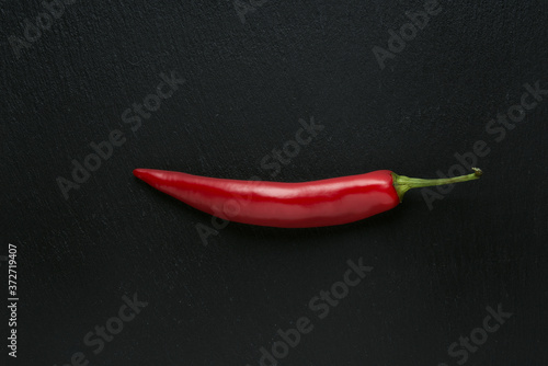 Isolated hot red pepper on black background, ingredient for recipes