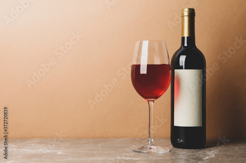 Bottle and glass of wine on gray table, space for text