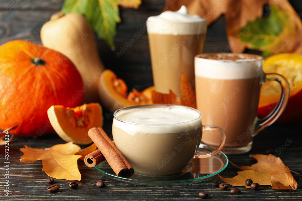Composition with pumpkin latte, cinnamon and pumpkin on wooden background Composition with pumpkin latte, cinnamon and pumpkin on wooden background