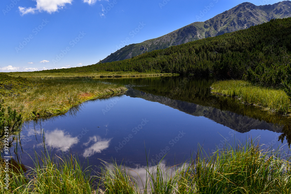The mountains, forests and lakes in the Tatra Mountains in Slovakia. Clouds reflected in the water.  Breathtaking views in mountains. Mountains in Slovakia (Bielanskie Tatry, Tatry Bielskie)

