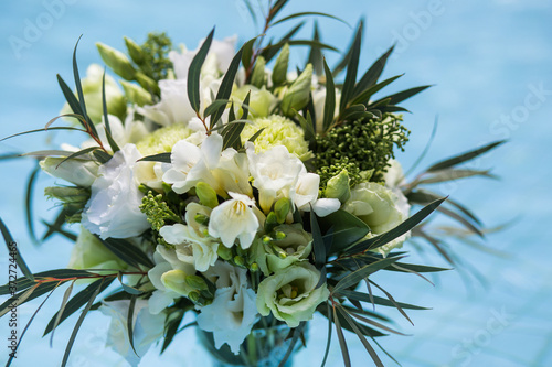 
Bridal bouquet of white eustomas on a background of blue water surface. photo