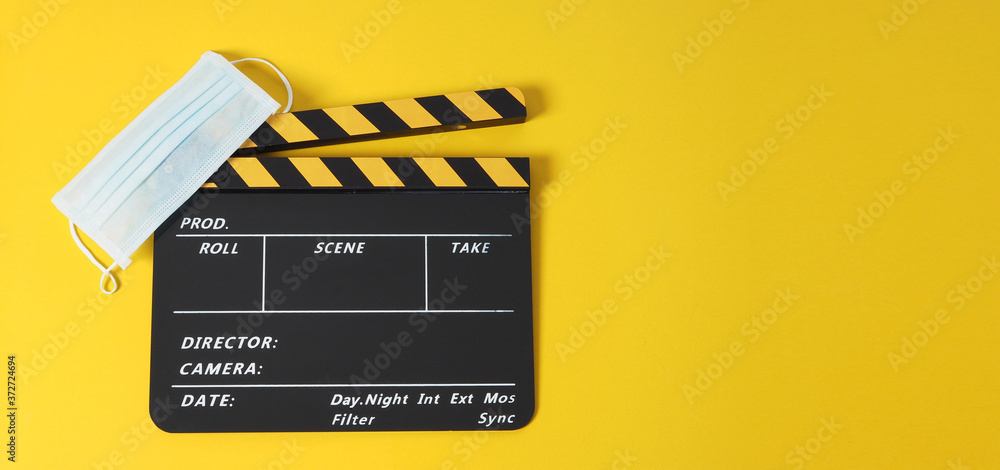 clapper board or movie clapperbpard or slate and face mask on yellow background.