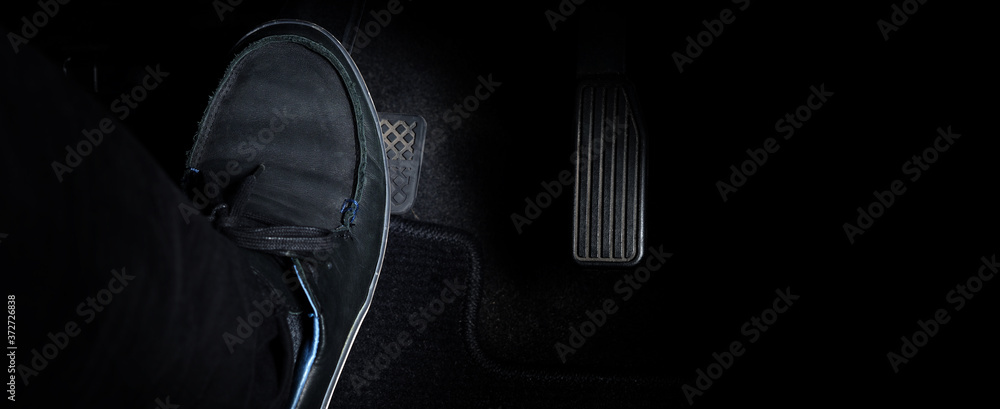 Εκτύπωση καμβά Man foot and accelerator and brake pedal inside the car or vehicle and copy space which black color leather shoe stepped on it for speed up or control automobile pace power