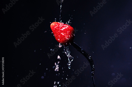 Strawberry on a fork. Freeze motion splash water