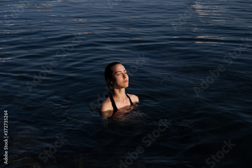 Young woman resting alone. Picture of calm relaxed girl in water swimming.Enjoy summer vacation 2020.Girl  model in the sea. The image of life  style  fashion  beauty.