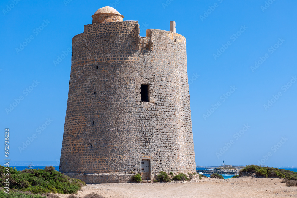 View of the old observation tower Torre De Ses Portes on the coast of the Ibiza island.