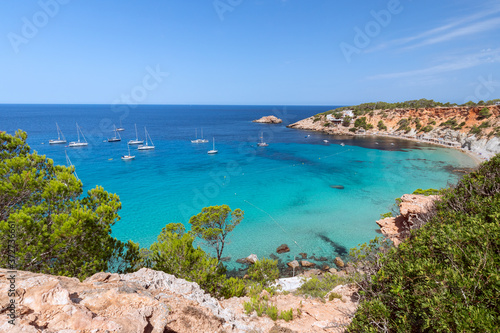 Beautiful Panorama of bay Cala Hort with sea sailing yachts. Ibiza, Balearic Islands, Spain