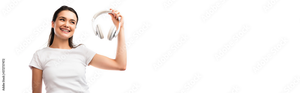panoramic shot of young woman in white t-shirt looking at wireless headphones isolated on white panoramic shot of young woman in white t-shirt looking at wireless headphones isolated on white