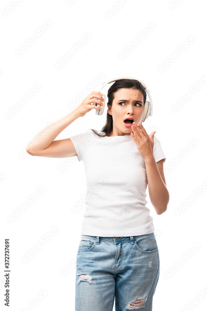 shocked young woman in white t-shirt touching wireless headphones isolated on white shocked young woman in white t-shirt touching wireless headphones isolated on white