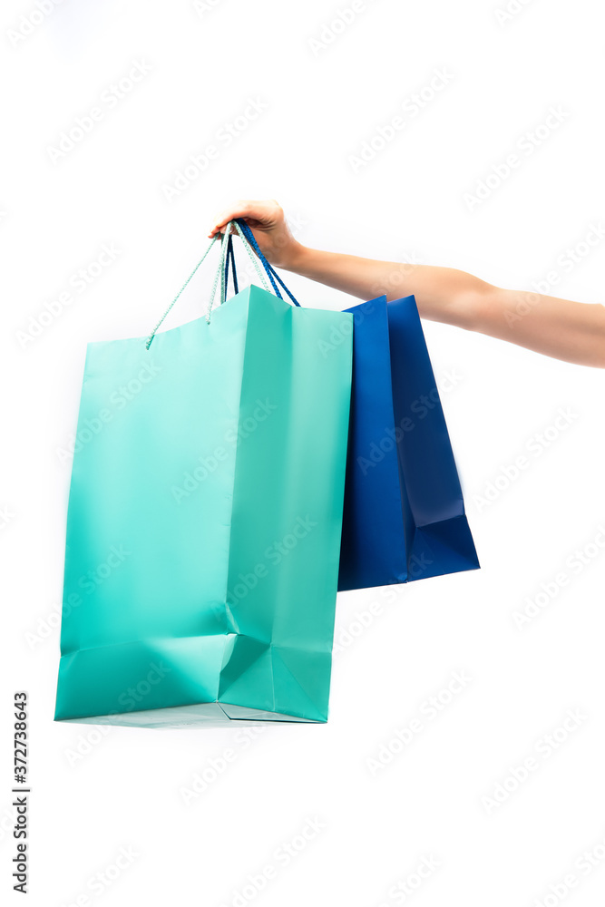 cropped view of woman holding colorful shopping bags isolated on white