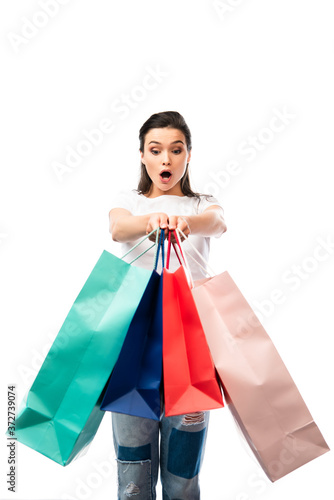 shocked woman looking at shopping bags isolated on white