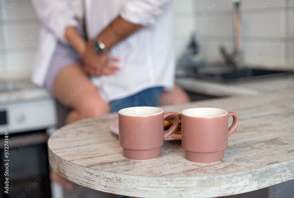 A pair of pink coffee cups. Kitchens in light colors. Breakfast cooking. Modern interior in the style of minimalism. Hot tea with cookies. Gentle morning for a couple in love holding hands A pair of pink coffee cups. Kitchens in light colors. Breakfast cooking. Modern interior in the style of minimalism. Hot tea with cookies. Gentle morning for a couple in love holding hands