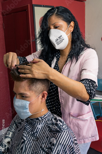 Estilista cortando el cabello en tiempos de covid photo