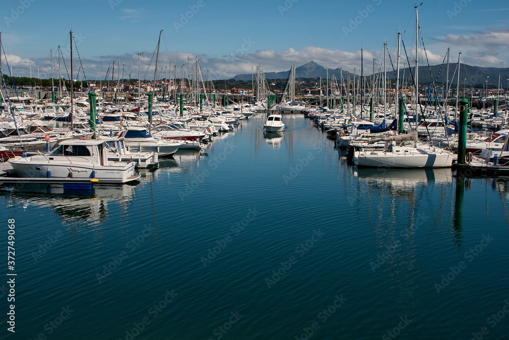 Boats moored in port and one preparing to leave the port
