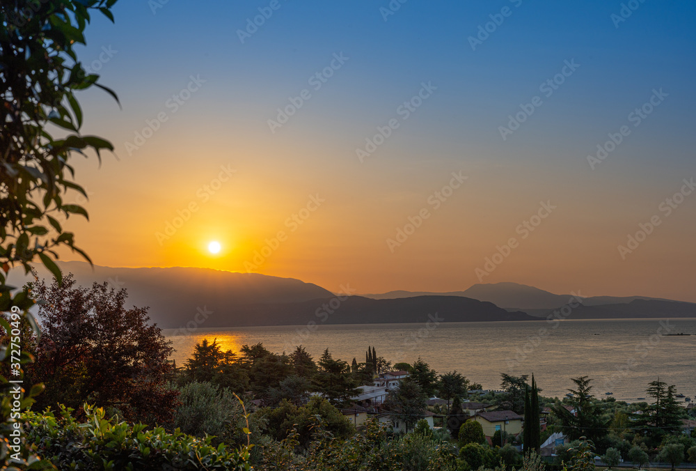 Sunrise in Manerba del Garda with the silhouettes of the mountains in the background on Lake Garda, Italy