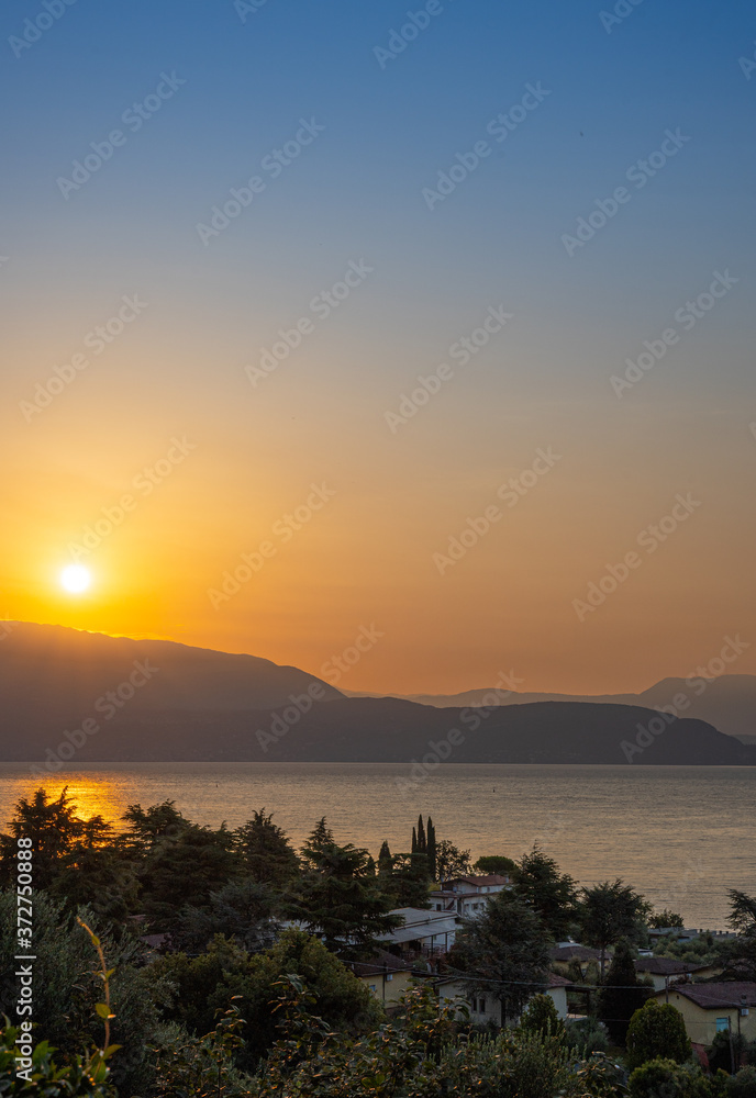 Sunrise in Manerba del Garda with the silhouettes of the mountains in the background on Lake Garda, Italy